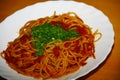 Plate with pasta, tomatosauce, basil and other herbs seafood