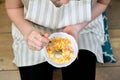 Close-up of plate with fruit salad in hands of eating woman sitting at home Royalty Free Stock Photo