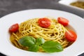 Close-up plate with italian pasta with pesto sauce, garnished with cherry tomatoes and basil leaves Royalty Free Stock Photo