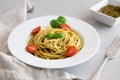 Close-up plate with italian pasta with pesto sauce, garnished with cherry tomatoes and basil leaves Royalty Free Stock Photo