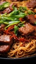 Close up of plate of noodles with beef and green onions. Noodles are thick and beef tender and flavorful. Green onions fresh and