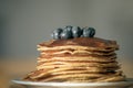 Close up of plate of pancakes on white plate with blueberries on top