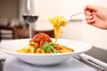 Close up of a plate pasta with shrimp. With a fork taking some pasta