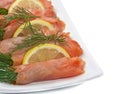 Close-up of plate with smoked salmon on white background.