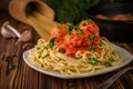 Close-up a plate of spaghetti with meatballs in tomato sauce and raw spaghetti with a frying pan in the background Royalty Free Stock Photo