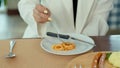 Close Up A plate of spaghetti with a woman`s hand holding on to a fork to write down the spaghetti in action with a knife beside Royalty Free Stock Photo