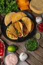 Close-up of plate with tasty mexican tacos on rustic wooden table with ingredients for cooking background. Concept of traditional Royalty Free Stock Photo