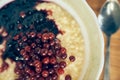 A close-up of a plate of wheat porridge for a healthy gluten-free breakfast. Warm wheat porridge with red currants and