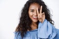 Close-up playful and feminine coquettish, african-american curly-haired female in blue blouse, silly showing tongue