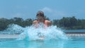 CLOSE UP: Girl pinches her nose and jumps into beautiful crystal clear water,