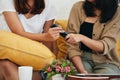 Close up playful young adult two sisters holding and hand over black remote control Royalty Free Stock Photo