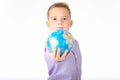 Close up Playful young caucasian school boy holding and shows in front a globe on white studio background Royalty Free Stock Photo
