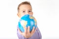 Close up Playful young caucasian school boy holding and shows in front a globe on white studio background Royalty Free Stock Photo
