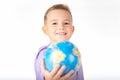 Close up Playful young caucasian school boy holding and shows in front a globe on white studio background Royalty Free Stock Photo