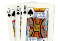 A close up of playing cards showing a jack, queen and king of spades.