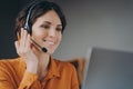 Pleasant woman Spanish speaking call center employee in wireless headset talking with client Royalty Free Stock Photo