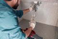 Close up of plumber is repairing faucet of a sink at bathroom using adjustable wrench Royalty Free Stock Photo