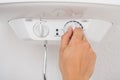 Plumber`s Hand Adjusting Temperature Of Electric Boiler