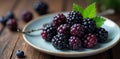 Close up of plump blackberries; spoon, plate, branch , plate, macro, visual Royalty Free Stock Photo