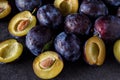 Close up of plums and plums slices on dark background Royalty Free Stock Photo