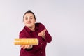 Close up of plus size woman showing pack of cookies isolated on grey background. Body positive and confident gesture Royalty Free Stock Photo