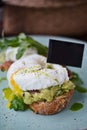 Close-up poached egg with yolk on toast with avocado and salad Royalty Free Stock Photo