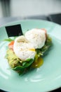 Close-up poached egg with yolk on toast with avocado and salad Royalty Free Stock Photo