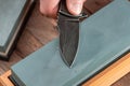 Close-up on a pocket knife being sharpened with a wet whetstone