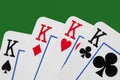 Close up on a poker of kings isolated on green table with copy space for your text