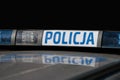 A close-up of a Polish police sign on the roof of a police car, symbolizing law enforcement and safety in urban areas