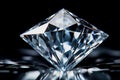 Close-up of a polished diamond reflecting light on a reflective surface Royalty Free Stock Photo