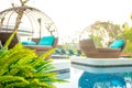 Close up poolside image with daybeds overlooking pool and a backlit morning glow