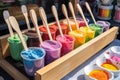 close-up of popsicle stand, with colorful frozen treats and spoons in view