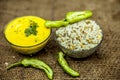 Close up of popular Indian & Asian lunch dish on brown colored surface i.e. Kadhi or Karhi and kichdi or chawal with fresh green