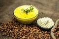 Close up of popular Indian & Asian lunch dish on brown colored surface i.e. Kadhi or Karhi and kichdi with raw cickpeas and besan