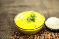 Close up of popular Indian & Asian lunch dish on brown colored surface i.e. Kadhi or Karhi and kichdi with raw cickpeas and besan