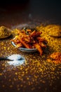 Close up of popular Indian cucumber pickle with all its ingredients including spices and herbs on a wooden surface in dark Gothic Royalty Free Stock Photo