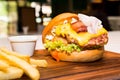 Close up on Pork burger with cheese, vegetable and served with fries Royalty Free Stock Photo