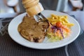 Close-up pork chop steak black pepper with men hand and black pepper sauce in white disk Royalty Free Stock Photo