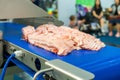 Close up pork or meat sliced on conveyor of automatic and precision slicer machine for industrial food manufacture