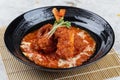 Close-up Pork rib chops steaks boiled with tomato sauce and cheese served in black round plate on makisu meal mat Royalty Free Stock Photo