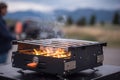 close-up of portable grill, with flames and smoke visible