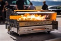 close-up of portable grill in motion, with smoke and flames coming from the burners