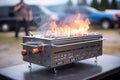 close-up of portable grill, with smoke and flames visible