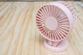 Close up pink portable USB fan on wooden frame for cool temperature