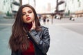 Close up portait of cute brunette girl in leather jacket, walking in the city around. Lifestyle, harmony concept.