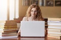 Close up portait of teenage girl studying and using new technologies, sitting at table in front of opened white lap top, lady Royalty Free Stock Photo