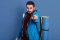 Close up portait of young caucasian man dresses maroon shirt and blue jacket, pointing at camera with his fore finger, bearded guy Royalty Free Stock Photo