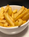 Close-up of a portion of chips in a white bowl on a black background