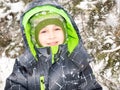 Close up portrait of adorable happy little boy grinning happily at the camera on a sunny winter`s day Royalty Free Stock Photo